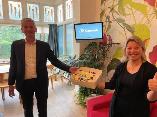 Zweder Bergman (VZVZ) feliciteert Metha Bregman (Careweb) met taart